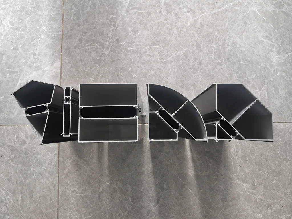 Four aluminium profile sections sawn during recent factory inspections, laid out in a row on a grey marble floor