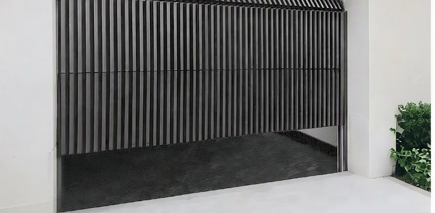 Black aluminium sectional garage door set in a white rendered wall
